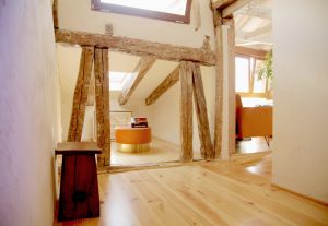 Recibidor muy luminosos con vigas de madera rústica y suelos de madera natural