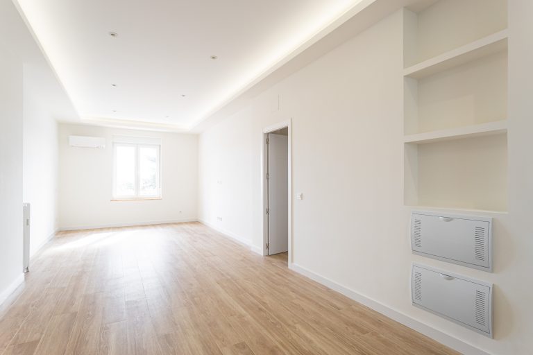 Vista de amplio salón muy luminoso con ventanas, hornacinas y candileja con iluminación led en el perímetro