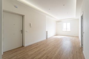 Vista de amplio salón sin amueblar, con iluminación led en el perímetro del salón