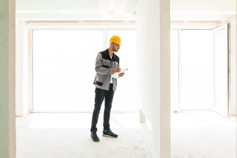 Vista de un técnico con casco amarillo haciendo revisión de obra
